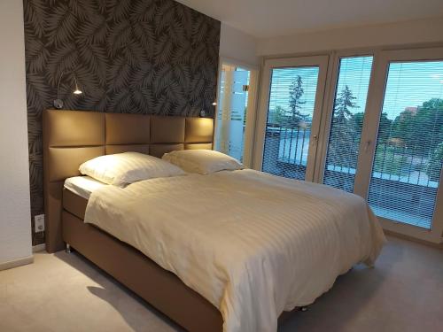 爱尔福特AT THE TOP - Penthouse über den Dächern der Stadt的卧室配有一张带白色床单和窗户的大床。