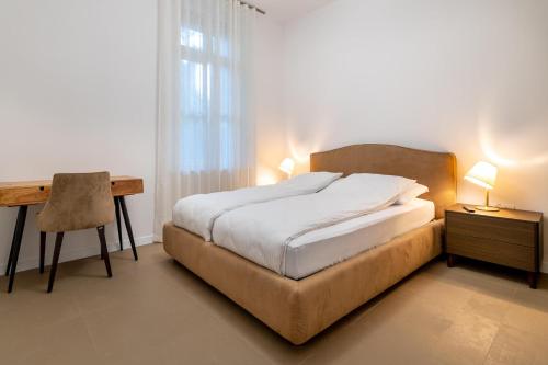 波尔托罗Luxury Apartments Portoroz的一间卧室配有一张床、一张桌子和一张书桌