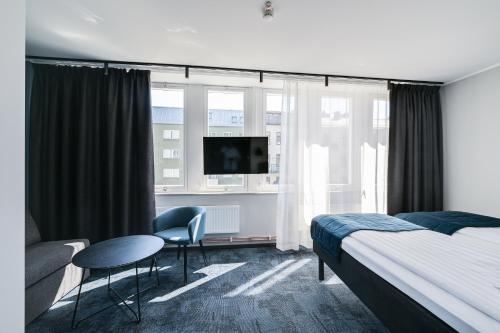 斯德哥尔摩Hotel Fridhem的酒店客房带一张床、一张桌子和椅子