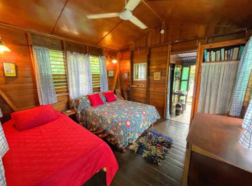 尼格瑞尔朱迪小屋和客房度假屋的一间小卧室,配有一张床和一张四柱床
