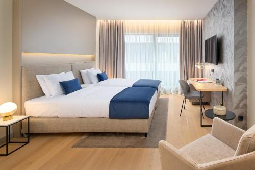 杜布罗夫尼克Boutique Hotel Porto的酒店客房设有一张大床和一张书桌。