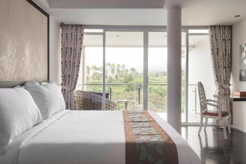 伦邦Lembang Views的一间卧室设有一张大床和一个大窗户