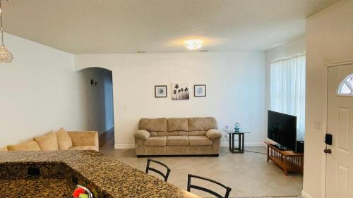 卡纳维拉尔角Casa Flamingo的带沙发的客厅和带桌子的客厅
