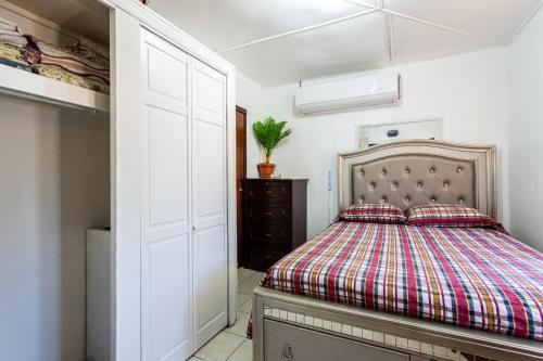 East End VillageMoonlight Cottage的一间卧室配有一张床和一个衣柜
