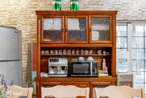 花莲市白色棉花糖民宿的厨房配有带微波炉的木柜