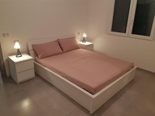 里米尼Villa Lina的一间卧室配有一张带两张台灯的床铺。