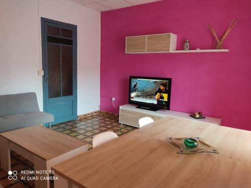 比纳罗斯Apartamento vinamar的客厅配有桌子和粉红色的墙壁