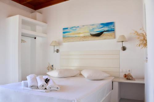 安迪帕罗斯岛Aegeo Inn的白色卧室,配有带毛巾的床
