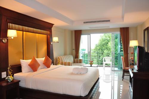 芭堤雅市中心八月套房酒店的酒店客房设有一张床和一个阳台。