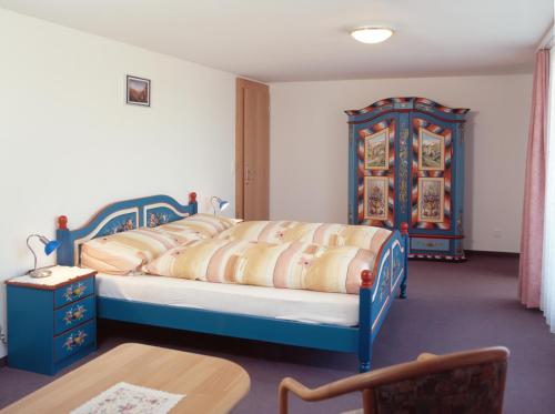 阿彭策尔Panorama Hotel Freudenberg的一间卧室配有一张蓝色的床和一张桌子