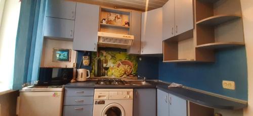 陶格夫匹尔斯Vienibas 38a的厨房配有白色橱柜和洗衣机。