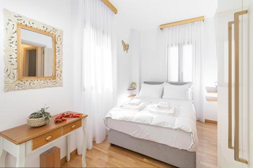 林都斯Villa Dafni - Lindos的白色卧室配有床和镜子
