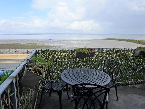 莫克姆货运专线酒店的俯瞰大海的阳台配有桌椅