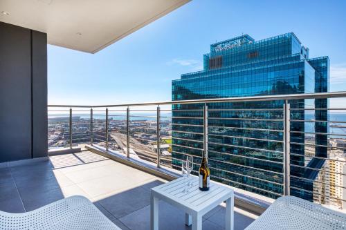 开普敦Always-Power Luxury Sky Retreat的阳台配有白色桌子,大楼