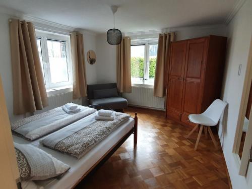 蒙绍Eifel-Oase Monschau的一间卧室配有一张床、一把椅子和窗户。