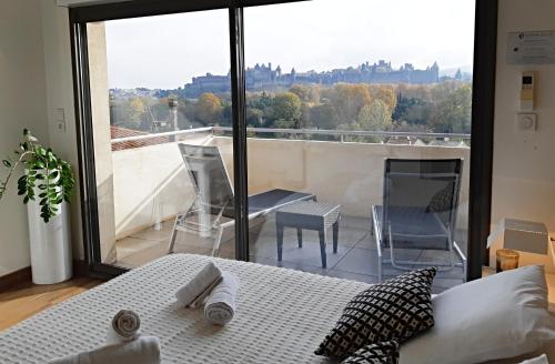 卡尔卡松圣纳泽尔城市阳台公寓的一间卧室设有一张床,享有阳台的景色