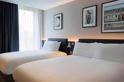 布里斯托Leonardo Hotel Bristol City的酒店客房设有两张床和窗户。