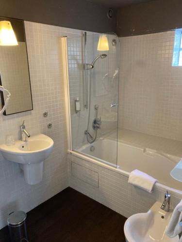 普雷讷夫昂德雷Hotel Georges的带淋浴、盥洗盆和浴缸的浴室