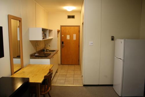 落基山庄CHINOOK INN的厨房配有木桌和冰箱。