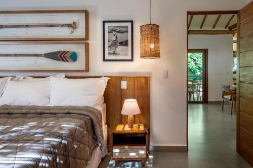托兰克索Flamboyant Residence Quadrado的一间卧室配有一张床和一张带台灯的桌子