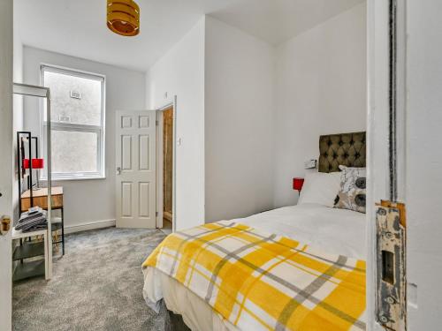 曼彻斯特Albert View Rooms的卧室设有黄色和白色的床和窗户。