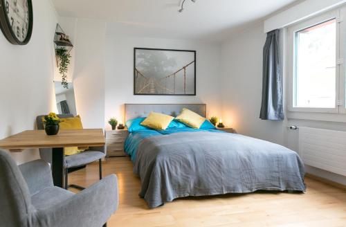 英格堡Spirit Apartments - Neben dem Titlis - Parkplatz的一间卧室配有一张带蓝色枕头的床和一张书桌