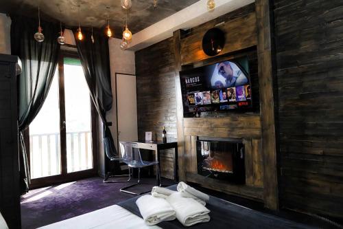 那不勒斯科沃德利安久依尼酒店的一间卧室设有壁炉、一张床和一台电视机。