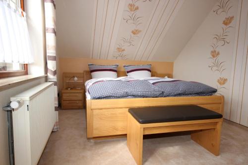 哈伦贝格玛里恩韦格度假屋酒店的一间带床和凳子的小卧室