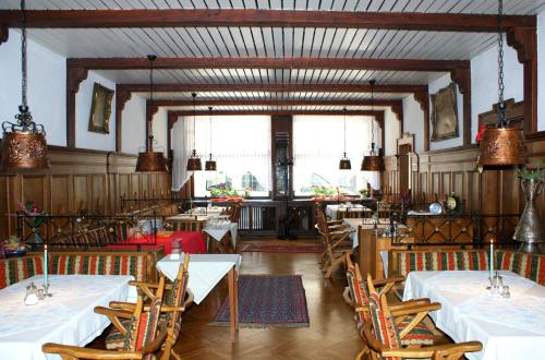 巴哈拉赫祖尔帕斯特酒店的用餐室配有白色的桌椅