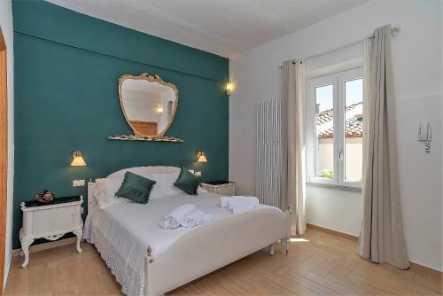 奥尔比亚La casa del pittore的卧室配有白色的床和镜子