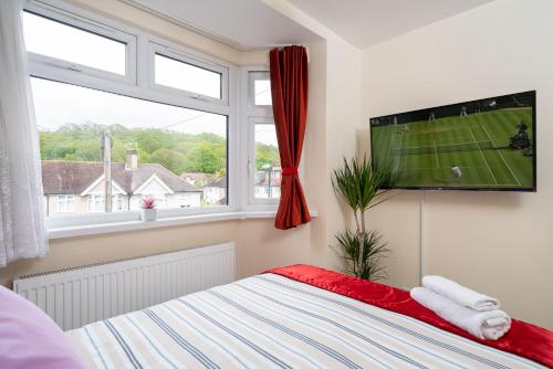 伦敦F4 Modern Double Room (Sandycroft Guest House)的一间卧室设有平面电视和一张床。
