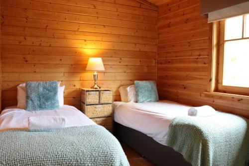 格拉斯哥Lodge 37 Rowardennan, Loch Lomond的木墙客房的两张床