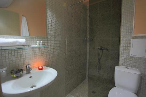 阳光海滩精品套房彩虹4酒店的带淋浴、卫生间和盥洗盆的浴室