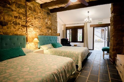 El Valle格兰德尔瓦莱酒店的一间卧室设有两张床和石墙
