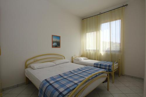 罗索利纳马雷Acquasmeralda appartamento 03的一间卧室设有两张床和窗户。