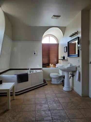 拜圣保罗橙色小栈宾馆的带浴缸、卫生间和盥洗盆的浴室