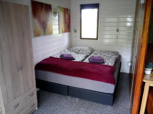 库福尔登Blokhut De Vlinder gelegen nabij het Pieterpad的一间小卧室,小房子里配有一张床