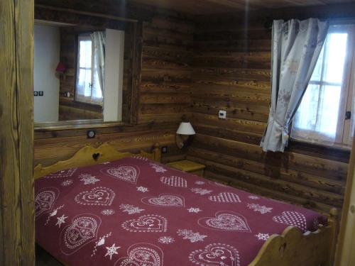 阿尔克河畔博讷瓦勒Chalet la Tuilière*****的小木屋内一间卧室,配有一张床