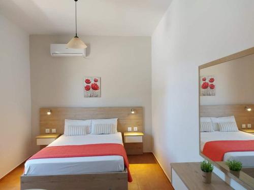 耶奥伊乌波利斯海神一室公寓的一间卧室配有两张红色和白色床单