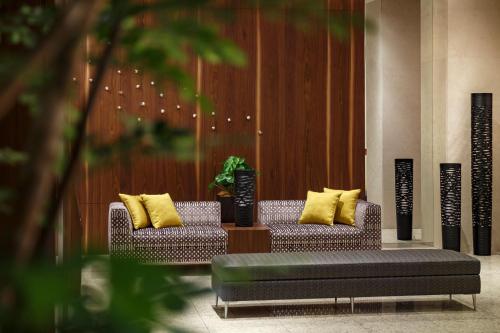 仙台仙台远景酒店的大堂设有两张带黄色枕头的沙发