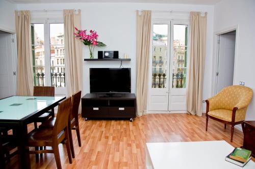 巴塞罗那克拉里斯公寓式酒店的客厅配有桌子和电视