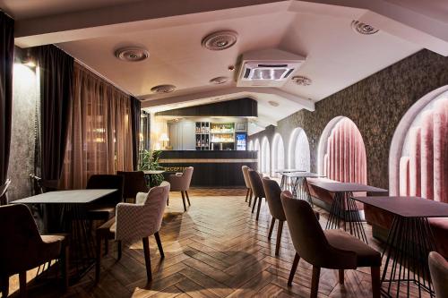 卡赞勒克Хотел Паризи的一间带桌椅的餐厅和一间酒吧