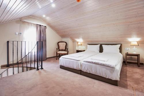 卡赞勒克Хотел Паризи的一间卧室配有一张大床和一把椅子
