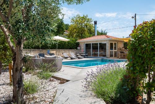 拉宾Apartments Bellistra Labin的庭院中带游泳池的房子