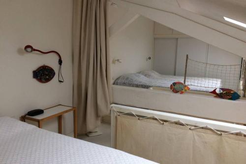 波克罗勒岛Appartement à 100 m du village de porquerolles的白色卧室配有床和镜子