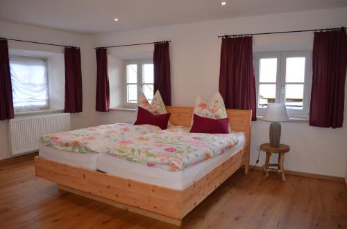 里姆斯廷格Ferienwohnung Fenzl的一间卧室配有一张带红色窗帘的木床