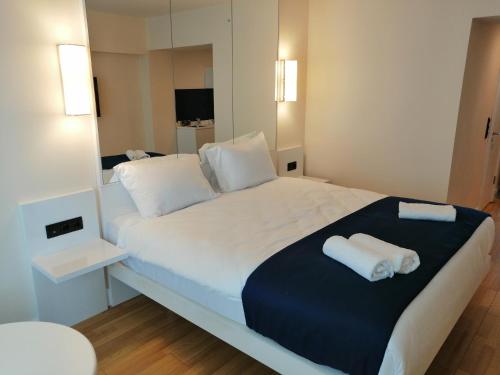 巴统Subtropik Apartments in Batumi的卧室配有一张白色大床和两条毛巾