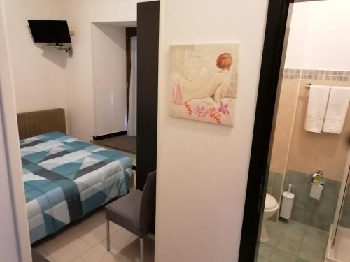 卡夏中心酒店的浴室设有一张床,墙上挂有绘画作品