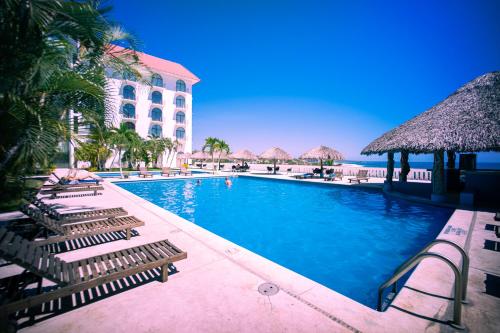 埃斯孔迪多港Hotel Caracol Plaza的一个带躺椅的游泳池和一间酒店