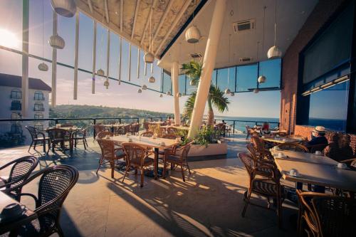 埃斯孔迪多港Hotel Caracol Plaza的一间带桌椅的海景餐厅